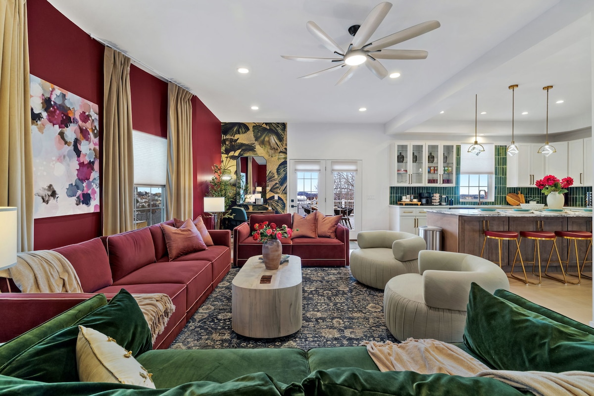 Restored living room and open kitchen at 130 Prospect Street, with jewel-toned sofas and green kitchen tile