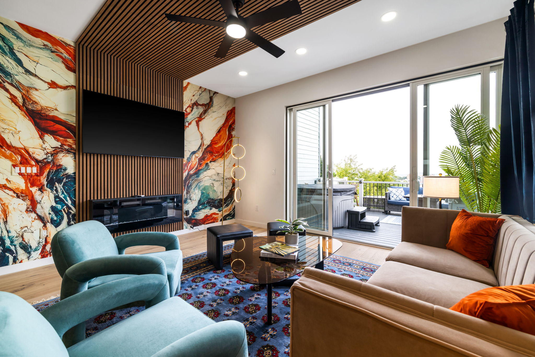 Completed living room at 132 Prospect Street, with a colorful fireplace wall, wood slat ceiling, and a deck beyond