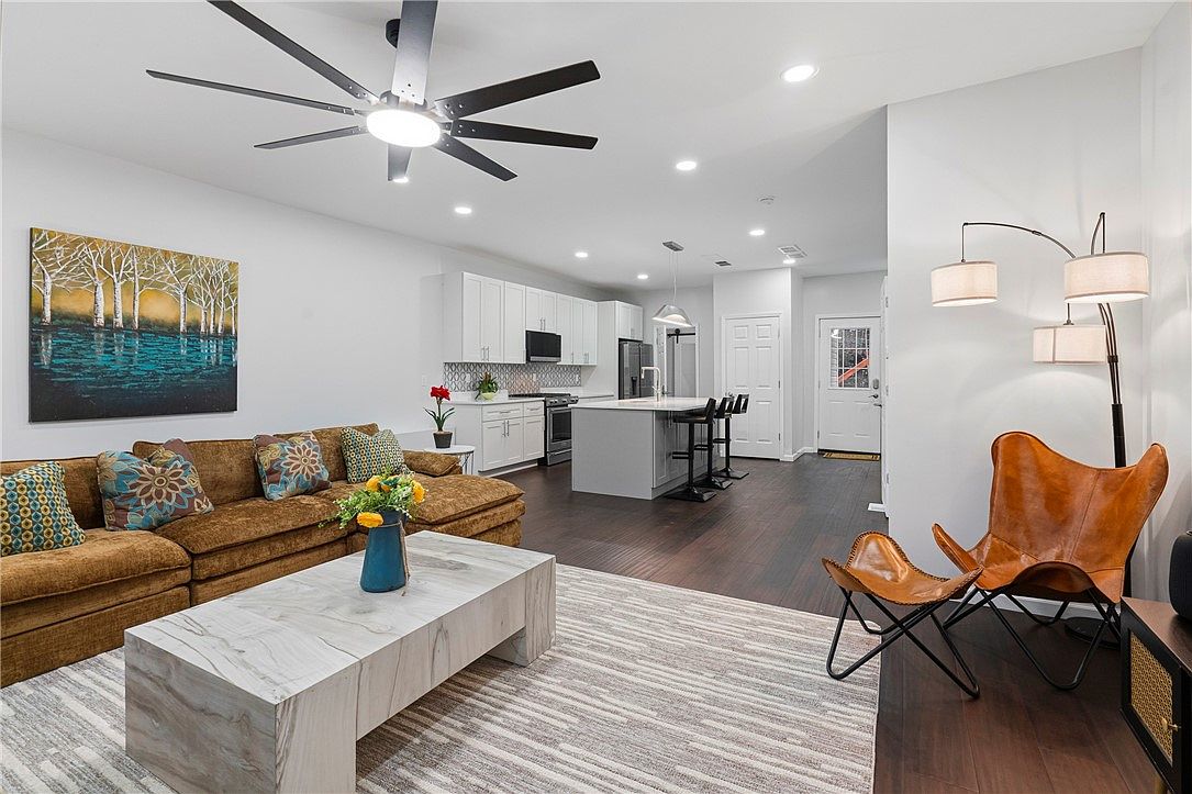 Renovated living room at 3354 Ridgway Street, with warm-toned seating and an open kitchen beyond